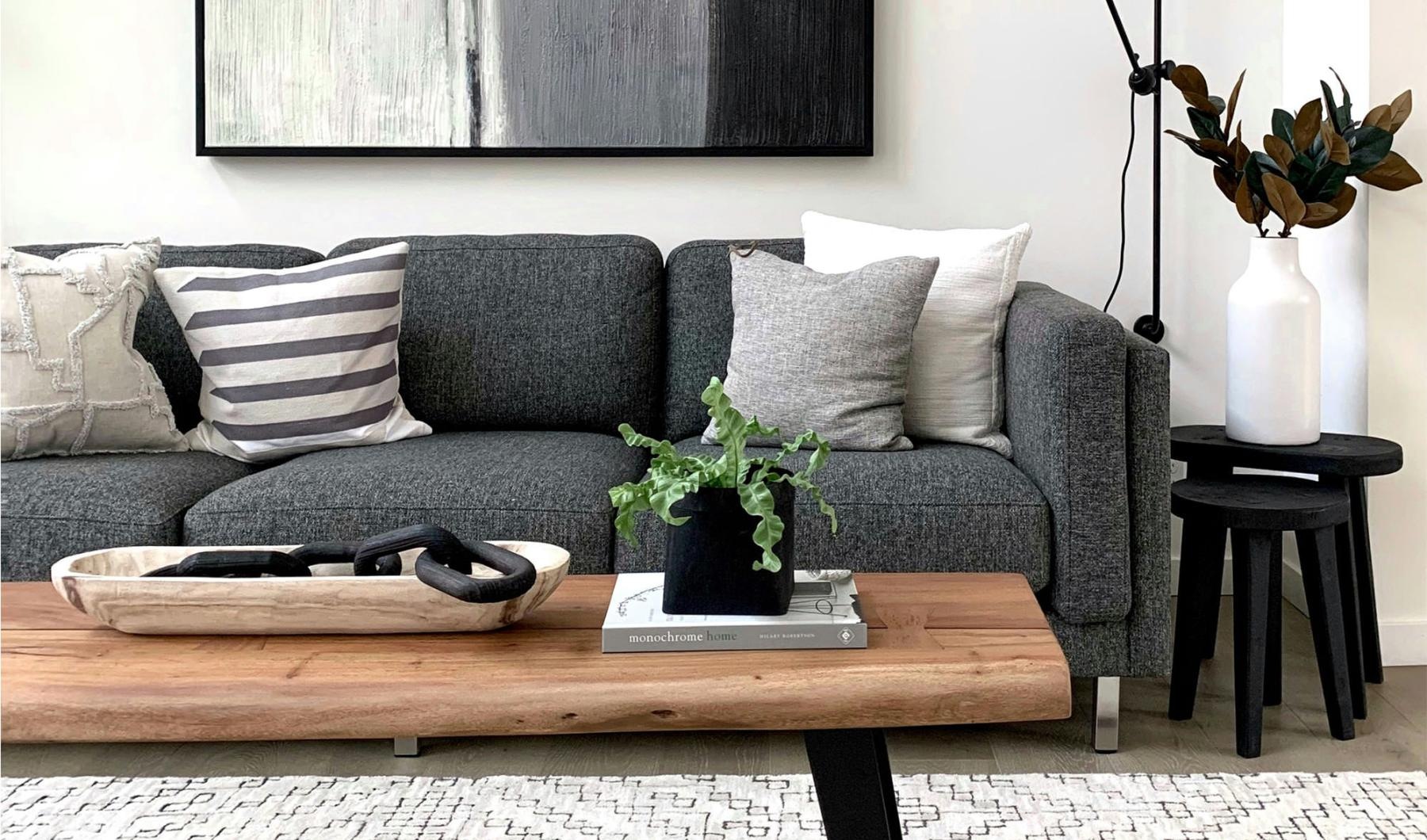 a couch with a coffee table with a plant and decor on it